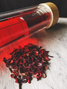 Hydrating hibiscus tea in water bottle with hibiscus tea flowers